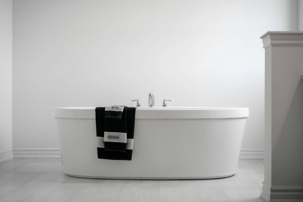 loofah bath mat for tub placed flat inside a bathtub with water droplets visible